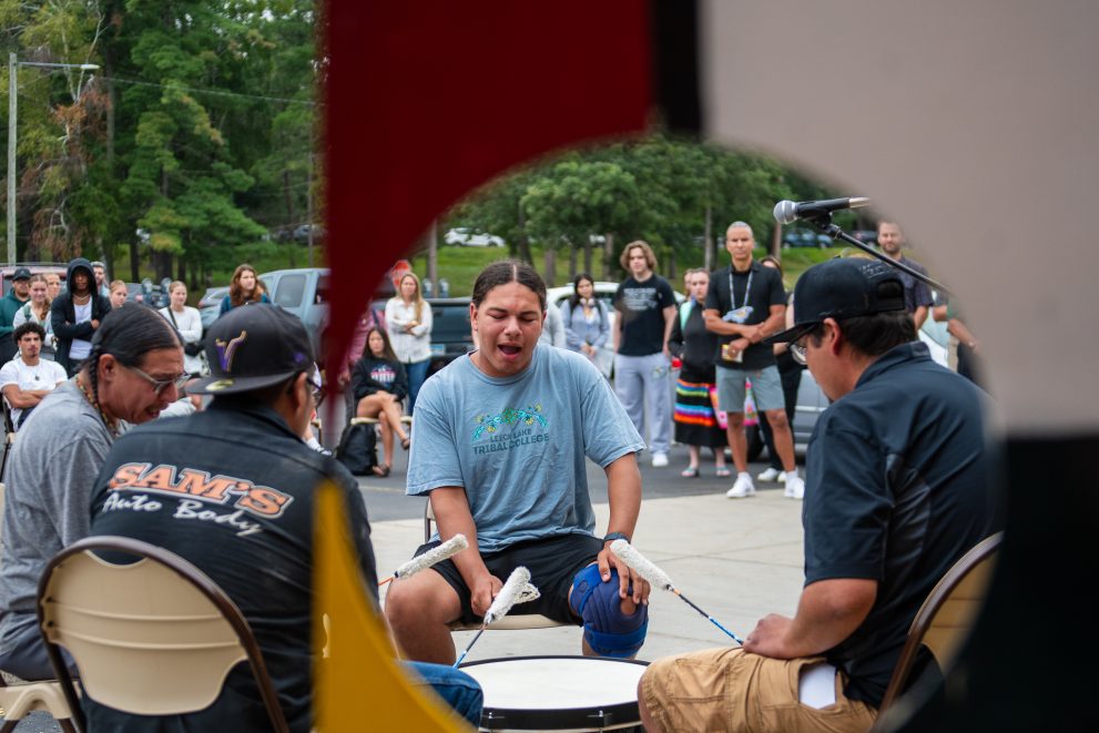 A traditional drum group signs an honor song