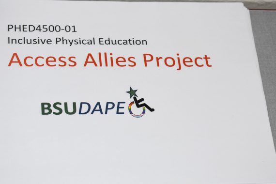 A paper sign which reads "PEHD4500-01 Inclusive Physical Education Access Allies Project BSU DAPE"