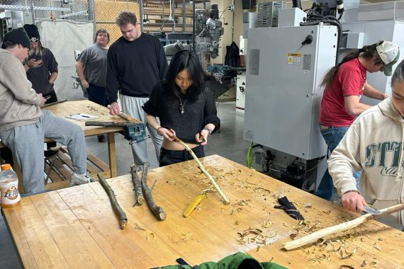 A student prepares her stick for painting