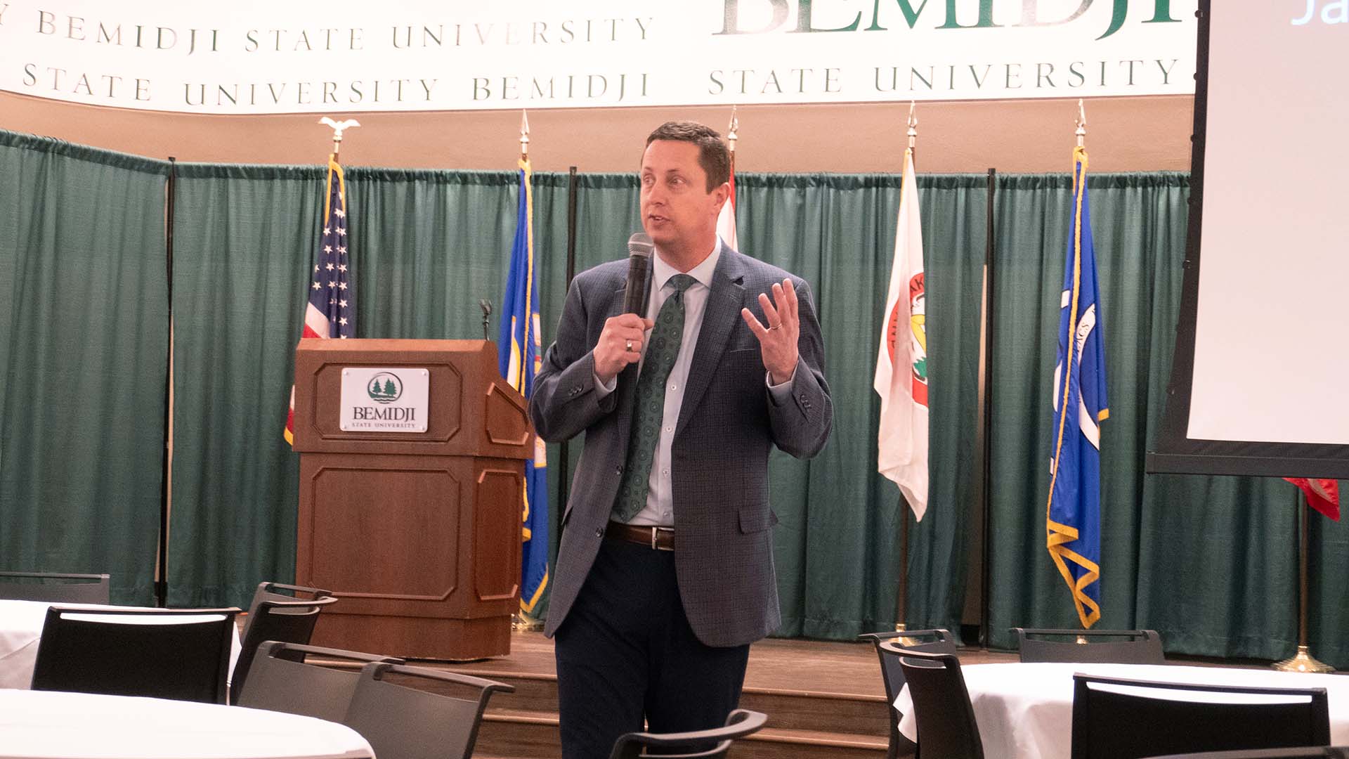 A stock image of BSU President John L. Hoffman speaking in front of a podium in BSU's Beaux Arts Ballroom