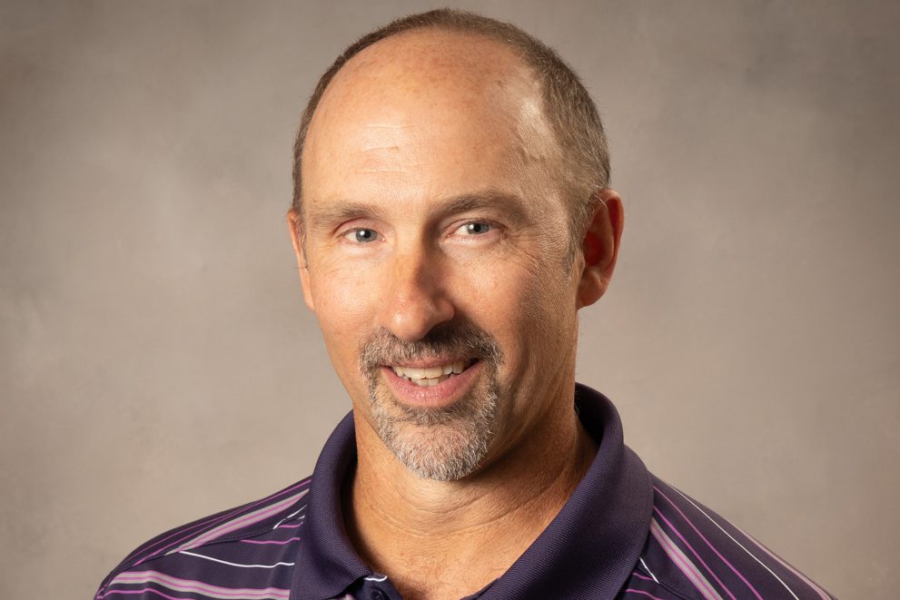 A photo of Dr. Todd Frauenholtz. He has a goatee and is wearing a striped purple shirt.