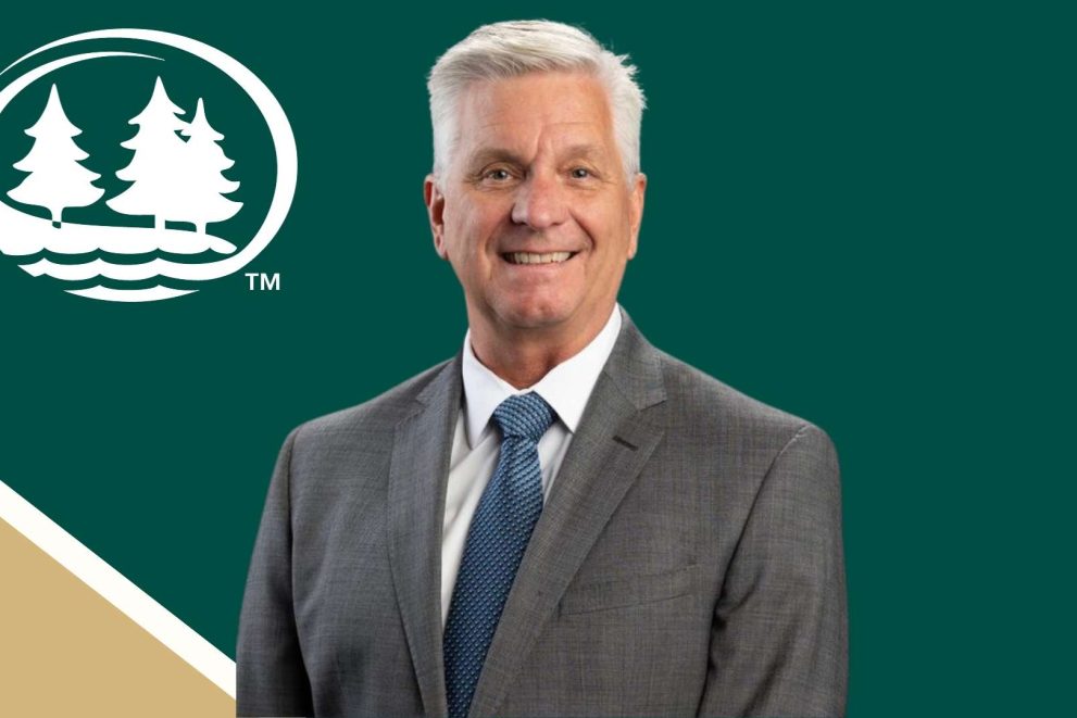 A photo of Christopher Waller against a dark green background with the BSU logo behind him.