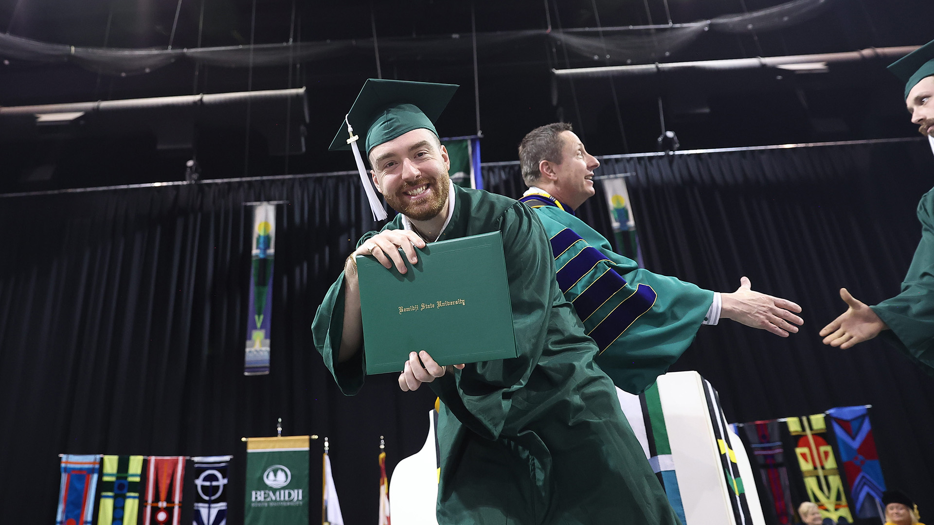A graduate shows off his diploma cover during BSU's 107th Commencement.
