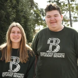 Student senate president and vice president posing for a photo outside.