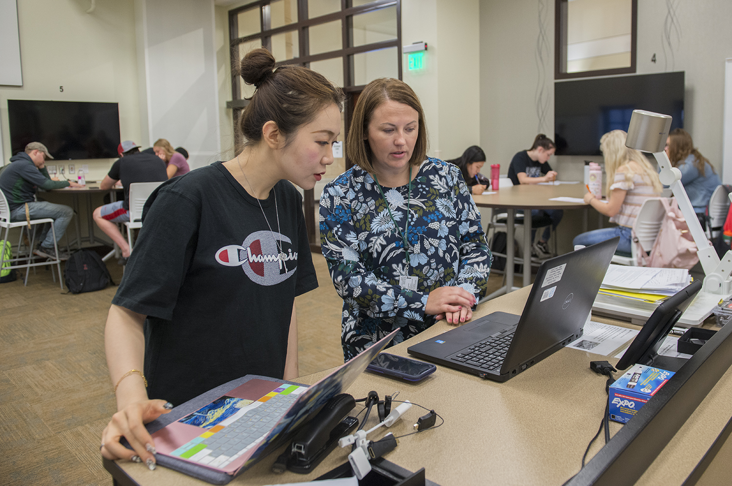 A professor showing a young female student something on her laptop