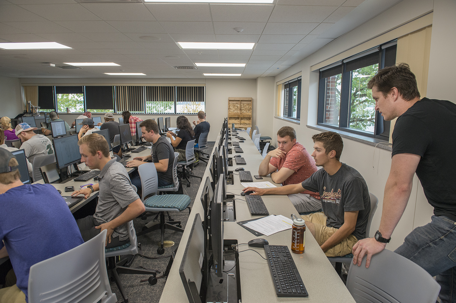 Rows of students sitting in front of computers, being advised