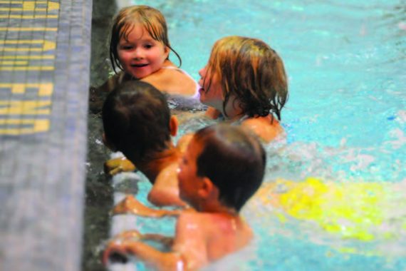 Children chatting at the edge of a pool