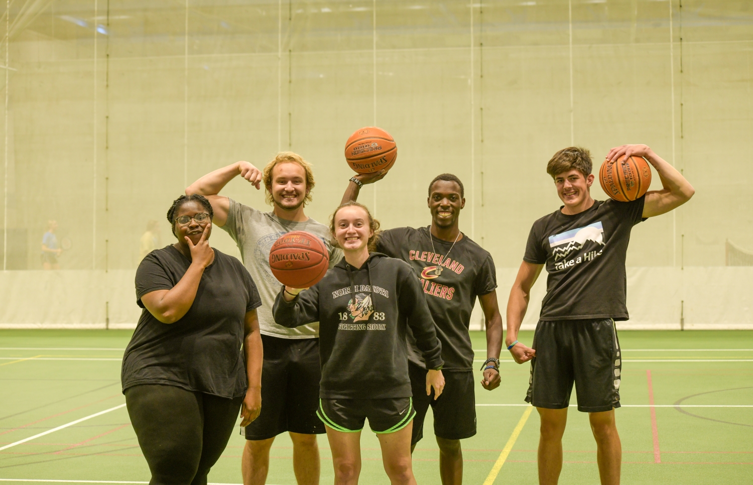 BSU students holding basketballs on the court