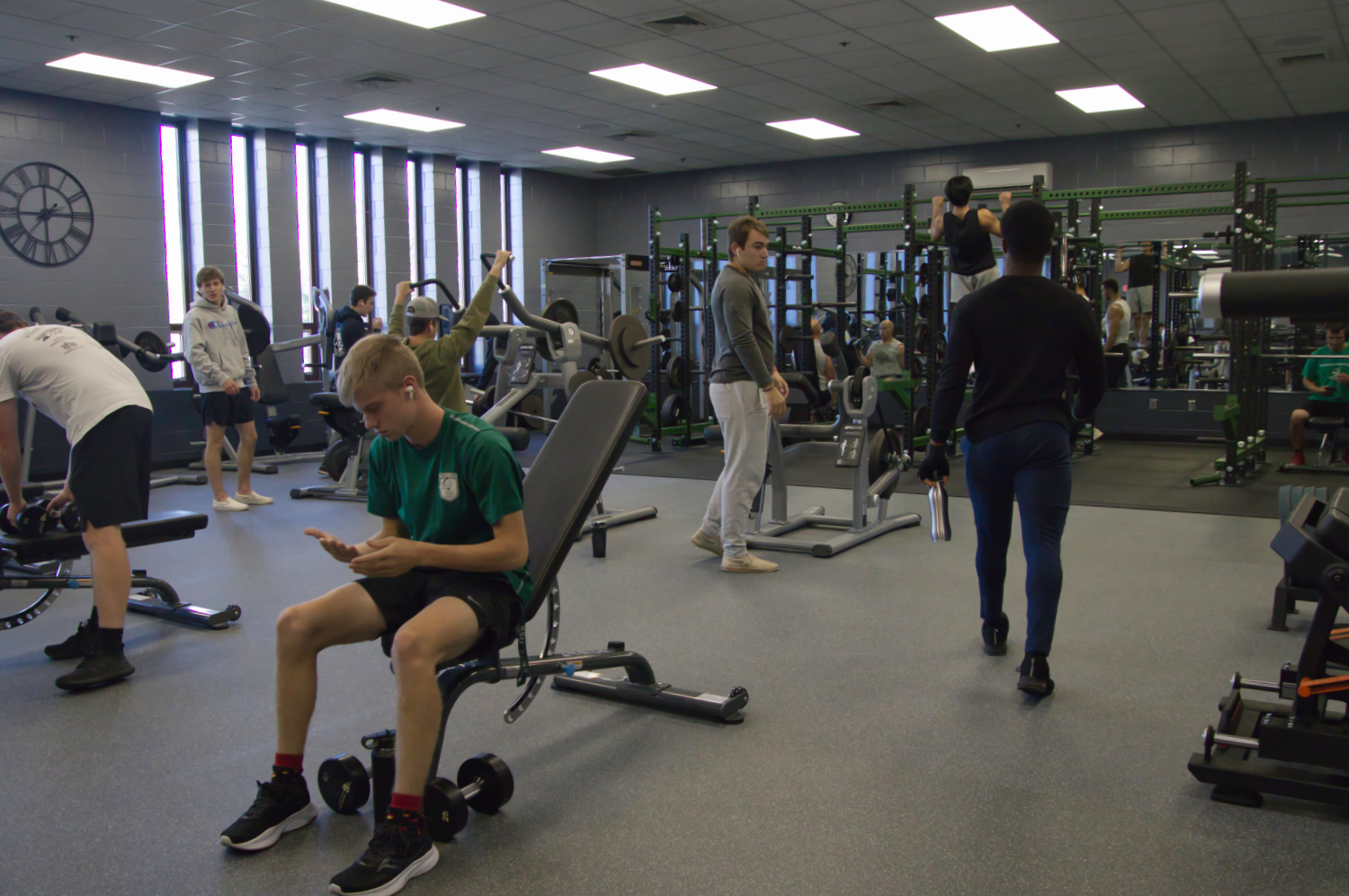 A group of students using equipment in a weight room