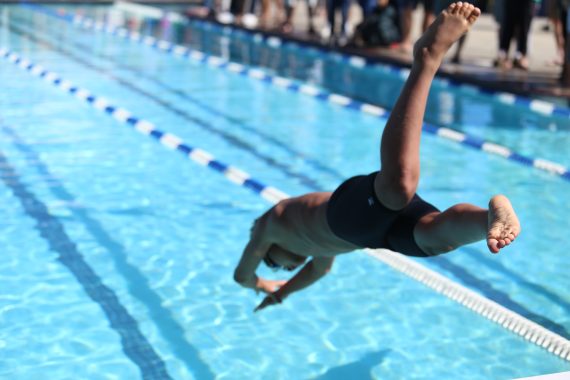 Young boy diving into a swimming pool