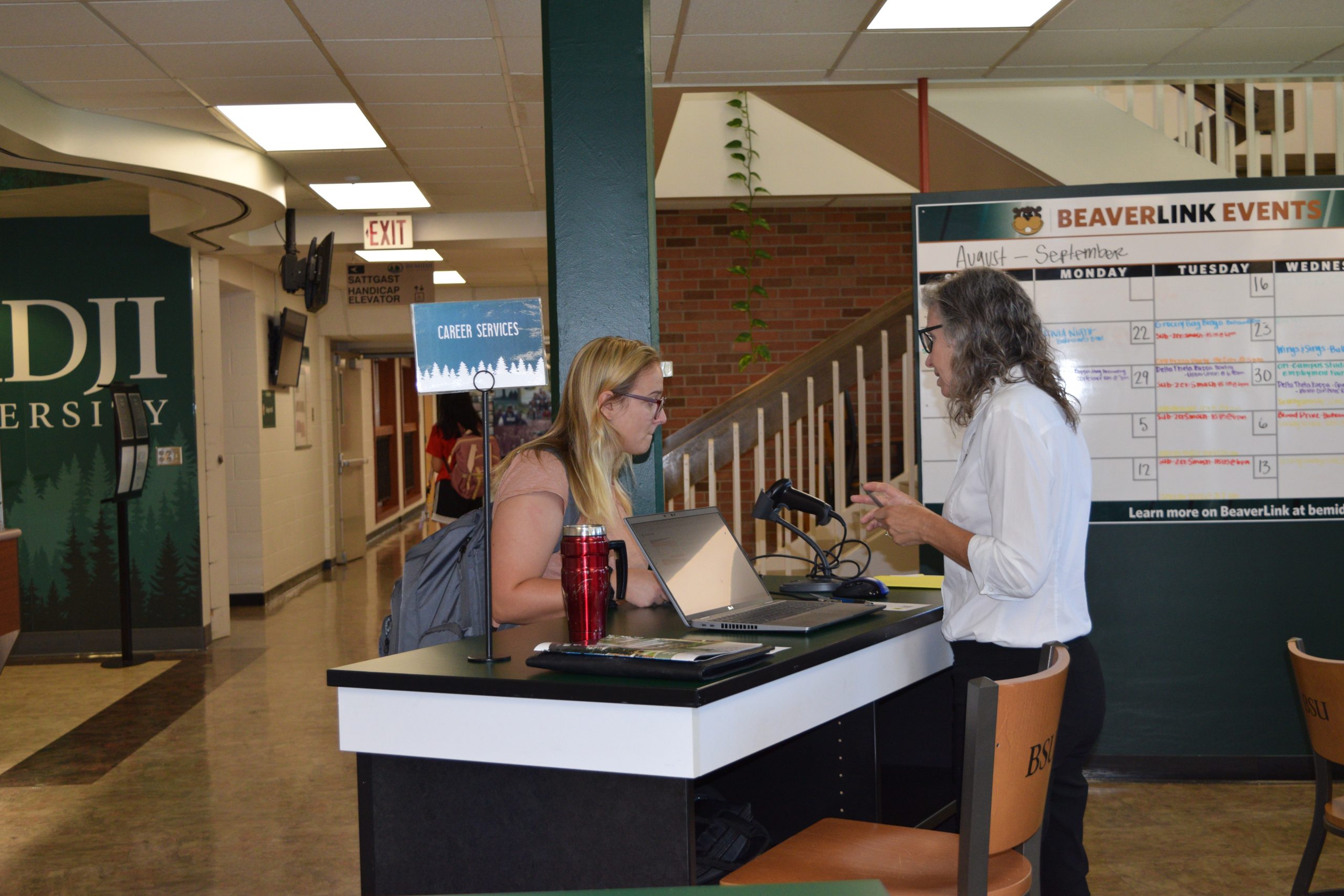 Career Services Booth in Lower Hobson Union with mentor talking to a young student