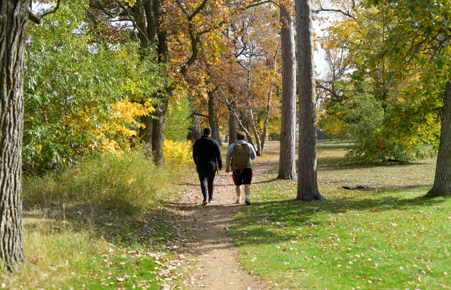 Two Bemidji State college students walking down a dirt path in the park