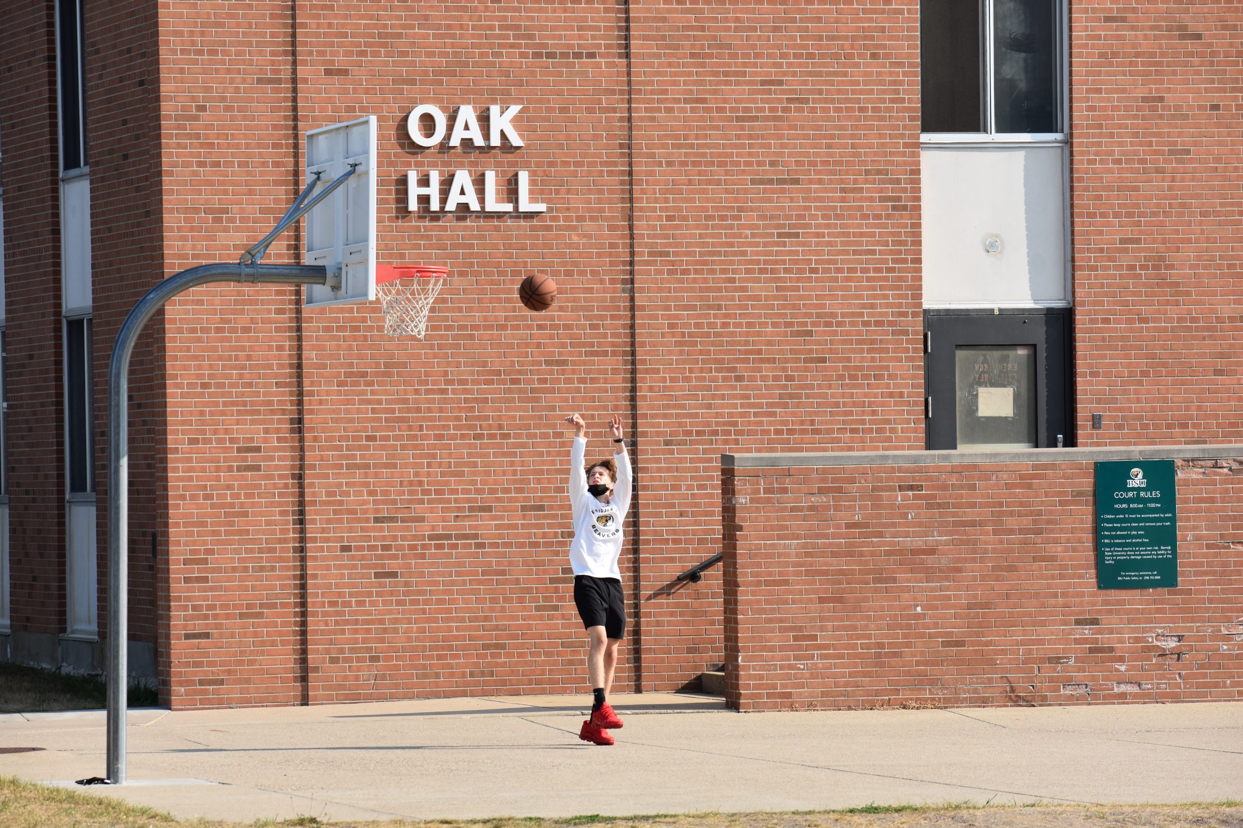Student Playing Basketball outside of Oak Hall