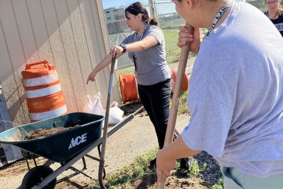 Students digging in the dirt and cleaning up