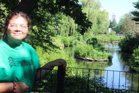 Student standing in front of a river on a bridge