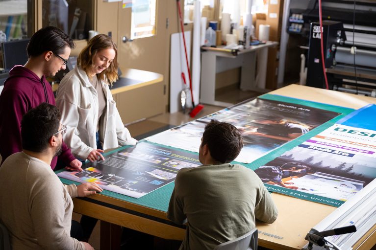students examine posters in BSU's large-format printing lab