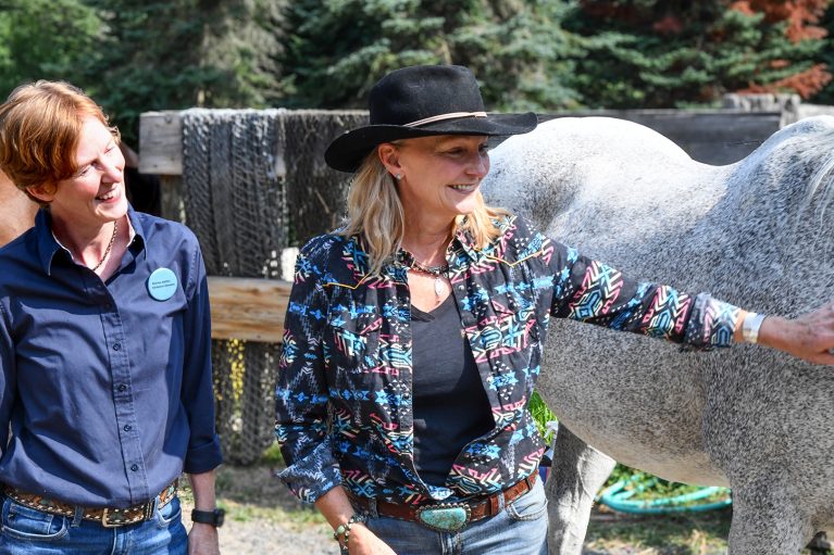 Dr. Angela Fournier (left) and Liz Letson with a grey horse named Tracker.